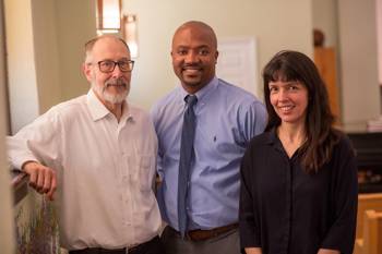 Two men and a women at John Hopkins University smile at the camera